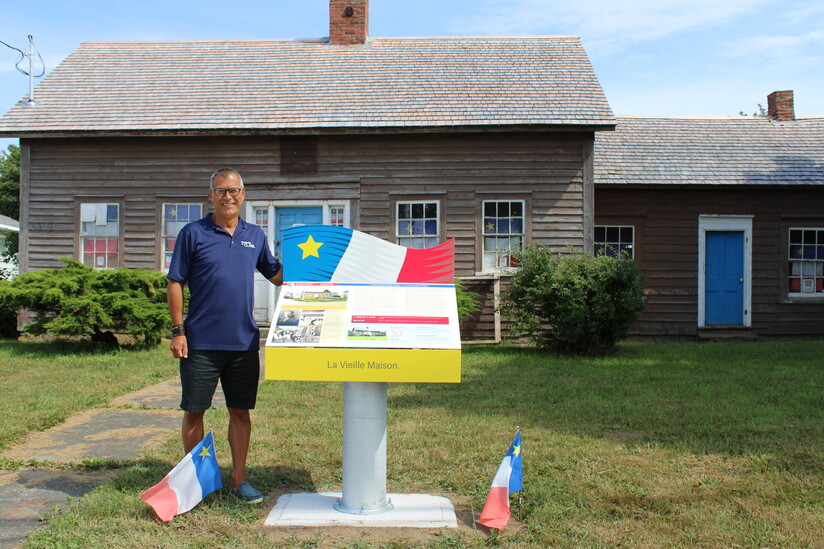 Une image du conseiller Carl Deveau devant un nouveau panneau d'interprétation à La Vieille Maison à Meteghan.